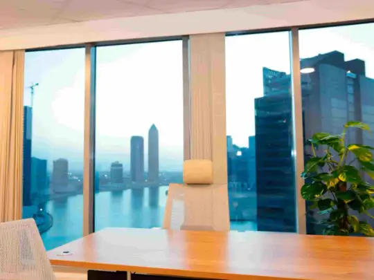 City skyline seen from office window, with tall buildings.